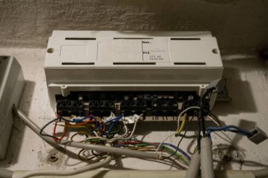 Renkli kablolar ve bileşenler içeren açık bir elektrik kontrol kutusunun yakınlaştırılması. Görüntü, endüstriyel ortamlarda elektrik dağıtımı, mühendislik ve sistem onarımına odaklanan teknik bir bakım anını betimliyor..