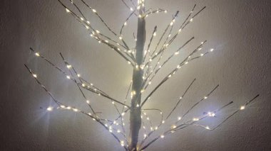 Dallarında ışıklar olan parıldayan dekoratif ağaç, kopyalama alanı, yeni yıl konsepti. 