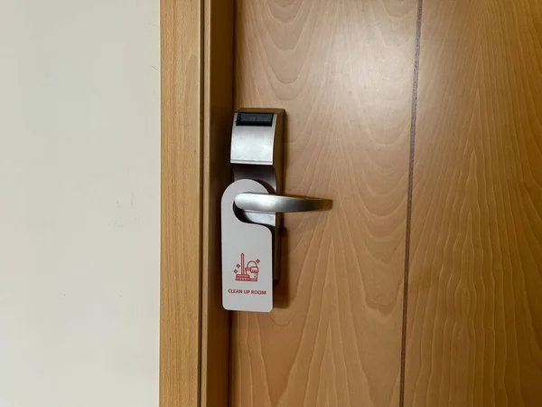 clean up room sign hanging on a hotel door handle concept of hotel room service request