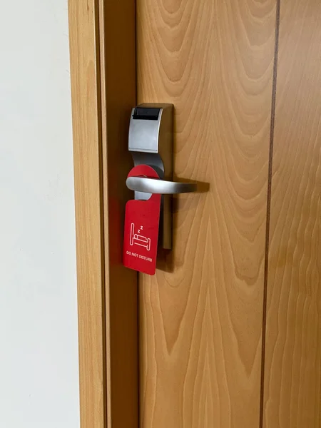 a red do not disturb sign on a hotel room door, concept of privacy and rest