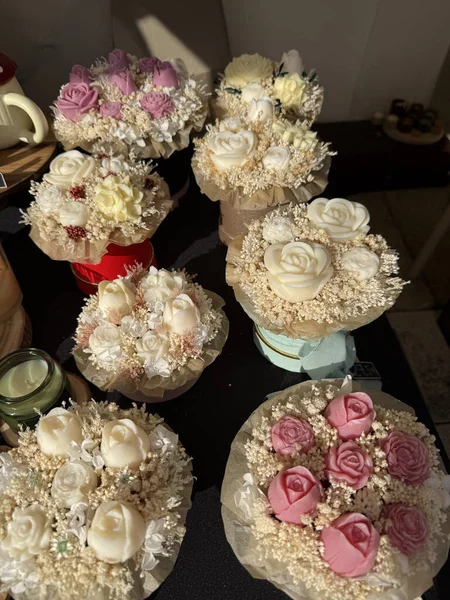 assortment of artisanal soap flower bouquets for sale at a market stall or shop display