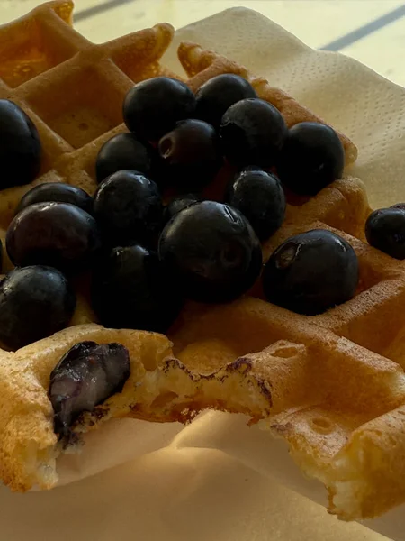 golden waffle with fresh blueberries on a white napkin close up concept of breakfast
