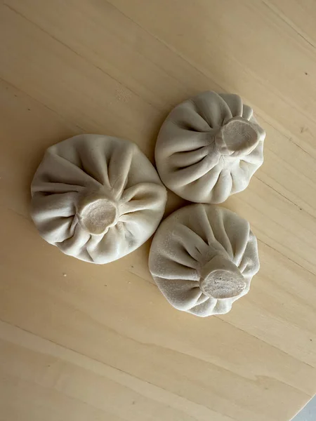 uncooked georgian khinkali on wooden surface ready for cooking concept of cuisine