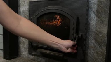 El, odun odununu yanan ocağa, sıcak ev ısıtma konseptine ekler..