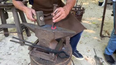 Demirci örse kızgın metali bir aletle vurdu, kapat