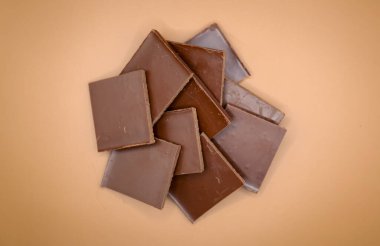 Kahverengi arka planda izole edilmiş çikolata parçaları. Yüksek kalite fotoğraf