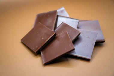 Kahverengi arka planda izole edilmiş çikolata parçaları. Yüksek kalite fotoğraf