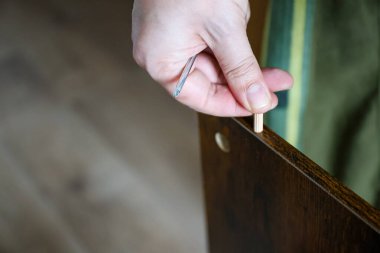 Bireylerin yakın plan çekimleri, beyaz bir yonga panelinin içine ahşap bir panel yerleştirmek, mobilya yapımını, kişisel işçiliği ve ev yenilemesini sembolize ediyor. Yüksek kalite fotoğraf