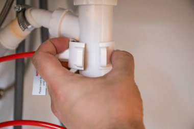 Sifonu batırmak için ters osmoz sisteminin drenaj borusunu bağlıyorum. Yüksek kalite fotoğraf