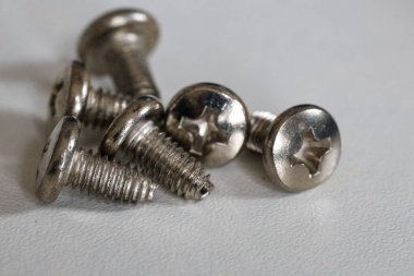 Beyaz yüzeyde gümüş vidalar var. Yüksek kalite fotoğraf