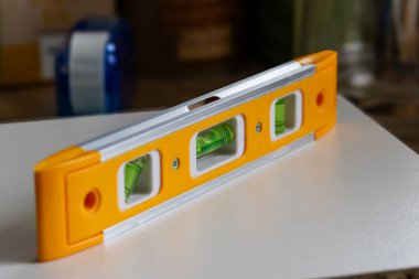 Beyaz yüzeyde izole edilmiş sarı renkli ruh seviyesi aracı ya da kabarcık seviyesi. Yüksek kalite fotoğraf