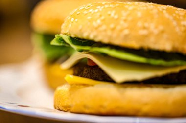 Peynirli, turşulu, soğanlı, domatesli, ketçaplı taze yapılmış hamburgerler. Fast food, aşçılık ve restoran temaları için mükemmel. Yüksek kalite fotoğraf