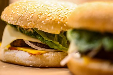 Peynirli, turşulu, soğanlı, domatesli, ketçaplı taze yapılmış hamburgerler. Fast food, aşçılık ve restoran temaları için mükemmel. Yüksek kalite fotoğraf