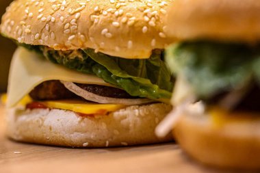 Peynirli, turşulu, soğanlı, domatesli, ketçaplı taze yapılmış hamburgerler. Fast food, aşçılık ve restoran temaları için mükemmel. Yüksek kalite fotoğraf