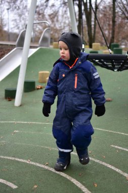 Kendine güveni tam bir çocuk boyalı çizgilerle oyun sahasında yürüyor. Çocuk sonbahar parkında dışarıda oynarken uzayı özgürce keşfeder. Çocuk dışarıda vakit geçiriyor..