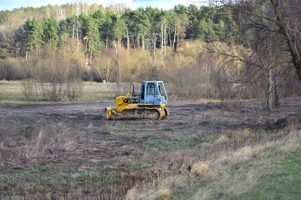 Buldozer kırsal kesimde karada, toprak hareketinde ve yer hazırlığında çalışıyor. Sanayi, kalkınma, altyapı ve arazi temizleme kavramları için uygun inşaat ve ağır makine sahnesi.