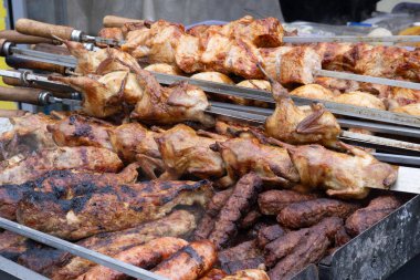 Izgara et ve kavrulmuş bıldırcın. Bir sokak yiyecek pazarında sıcak kömürlerin üstünde. Dumanlı ve altın sarısı kahverengi..