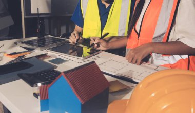 Endüstriyel mühendislerden oluşan bir ekip, fabrikadaki masada bulunan makine planlarını analiz ediyor. Fabrikada ya da üretim tesisinde çalışıyorum..