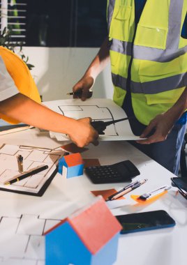 Endüstriyel mühendislerden oluşan bir ekip, fabrikadaki masada bulunan makine planlarını analiz ediyor. Fabrikada ya da üretim tesisinde çalışıyorum..