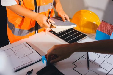 Endüstriyel mühendislerden oluşan bir ekip, fabrikadaki masada bulunan makine planlarını analiz ediyor. Fabrikada ya da üretim tesisinde çalışıyorum..