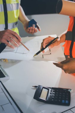 Endüstriyel mühendislerden oluşan bir ekip, fabrikadaki masada bulunan makine planlarını analiz ediyor. Fabrikada ya da üretim tesisinde çalışıyorum..