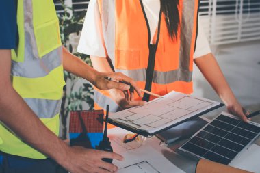 Endüstriyel mühendislerden oluşan bir ekip, fabrikadaki masada bulunan makine planlarını analiz ediyor. Fabrikada ya da üretim tesisinde çalışıyorum..