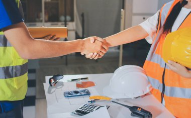 Endüstriyel mühendislerden oluşan bir ekip, fabrikadaki masada bulunan makine planlarını analiz ediyor. Fabrikada ya da üretim tesisinde çalışıyorum..