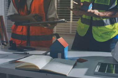 Endüstriyel mühendislerden oluşan bir ekip, fabrikadaki masada bulunan makine planlarını analiz ediyor. Fabrikada ya da üretim tesisinde çalışıyorum..