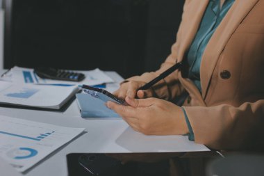 İşadamlarının yakın çekimleri notlar, cep telefonları, çizelgeler, masa, ofis