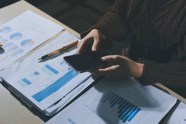 İşadamlarının yakın çekimleri notlar, cep telefonları, çizelgeler, masa, ofis