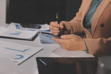 İşadamlarının yakın çekimleri notlar, cep telefonları, çizelgeler, masa, ofis