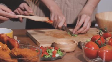 Genç çiftin birlikte evde mutfakta yemek.