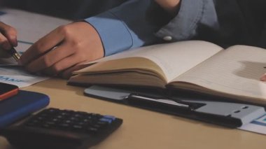 Muhasebe şirketi karlı nakit akışı için finansman ve vergilendirme planlaması, ofiste çalışan muhasebeci, mali verileri ve muhasebe kayıtlarını hesap makinesiyle analiz eder