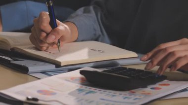 Muhasebe şirketi karlı nakit akışı için finansman ve vergilendirme planlaması, ofiste çalışan muhasebeci, mali verileri ve muhasebe kayıtlarını hesap makinesiyle analiz eder