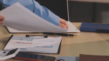 Muhasebe şirketi karlı nakit akışı için finansman ve vergilendirme planlaması, ofiste çalışan muhasebeci, mali verileri ve muhasebe kayıtlarını hesap makinesiyle analiz eder