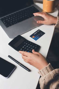 Kapanmış adam dizüstü bilgisayarı kullan kredi kartı kullan cep telefonu kullan kahve dükkanında masaya otur, dinlenme dinlenme dinlenme dinlenme dinlenme boş zamanlarında serbest mobil konsepte odaklan nesneye odaklan