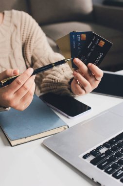 Kapanmış adam dizüstü bilgisayarı kullan kredi kartı kullan cep telefonu kullan kahve dükkanında masaya otur, dinlenme dinlenme dinlenme dinlenme dinlenme boş zamanlarında serbest mobil konsepte odaklan nesneye odaklan