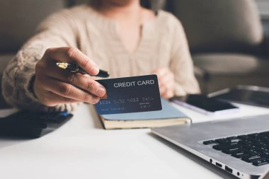 Kapanmış adam dizüstü bilgisayarı kullan kredi kartı kullan cep telefonu kullan kahve dükkanında masaya otur, dinlenme dinlenme dinlenme dinlenme dinlenme boş zamanlarında serbest mobil konsepte odaklan nesneye odaklan