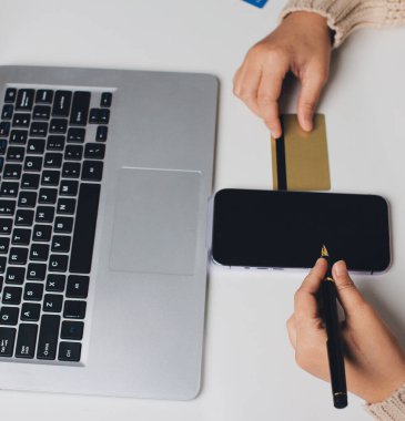 Kapanmış adam dizüstü bilgisayarı kullan kredi kartı kullan cep telefonu kullan kahve dükkanında masaya otur, dinlenme dinlenme dinlenme dinlenme dinlenme boş zamanlarında serbest mobil konsepte odaklan nesneye odaklan