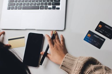 Kapanmış adam dizüstü bilgisayarı kullan kredi kartı kullan cep telefonu kullan kahve dükkanında masaya otur, dinlenme dinlenme dinlenme dinlenme dinlenme boş zamanlarında serbest mobil konsepte odaklan nesneye odaklan