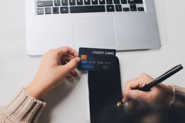 Kapanmış adam dizüstü bilgisayarı kullan kredi kartı kullan cep telefonu kullan kahve dükkanında masaya otur, dinlenme dinlenme dinlenme dinlenme dinlenme boş zamanlarında serbest mobil konsepte odaklan nesneye odaklan