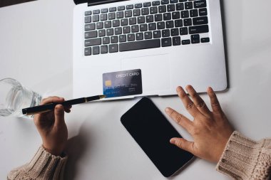 Kapanmış adam dizüstü bilgisayarı kullan kredi kartı kullan cep telefonu kullan kahve dükkanında masaya otur, dinlenme dinlenme dinlenme dinlenme dinlenme boş zamanlarında serbest mobil konsepte odaklan nesneye odaklan