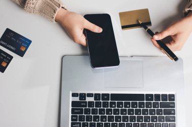 Kapanmış adam dizüstü bilgisayarı kullan kredi kartı kullan cep telefonu kullan kahve dükkanında masaya otur, dinlenme dinlenme dinlenme dinlenme dinlenme boş zamanlarında serbest mobil konsepte odaklan nesneye odaklan