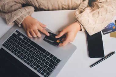 Kapanmış adam dizüstü bilgisayarı kullan kredi kartı kullan cep telefonu kullan kahve dükkanında masaya otur, dinlenme dinlenme dinlenme dinlenme dinlenme boş zamanlarında serbest mobil konsepte odaklan nesneye odaklan