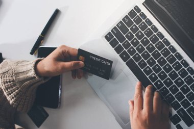 Kapanmış adam dizüstü bilgisayarı kullan kredi kartı kullan cep telefonu kullan kahve dükkanında masaya otur, dinlenme dinlenme dinlenme dinlenme dinlenme boş zamanlarında serbest mobil konsepte odaklan nesneye odaklan