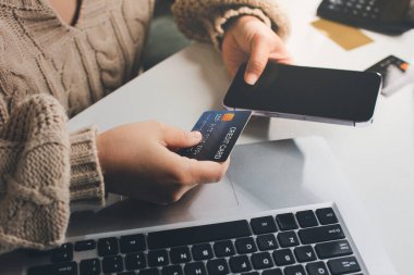 Kapanmış adam dizüstü bilgisayarı kullan kredi kartı kullan cep telefonu kullan kahve dükkanında masaya otur, dinlenme dinlenme dinlenme dinlenme dinlenme boş zamanlarında serbest mobil konsepte odaklan nesneye odaklan