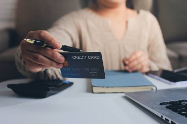 Kapanmış adam dizüstü bilgisayarı kullan kredi kartı kullan cep telefonu kullan kahve dükkanında masaya otur, dinlenme dinlenme dinlenme dinlenme dinlenme boş zamanlarında serbest mobil konsepte odaklan nesneye odaklan