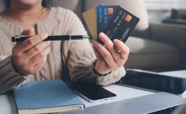 Kapanmış adam dizüstü bilgisayarı kullan kredi kartı kullan cep telefonu kullan kahve dükkanında masaya otur, dinlenme dinlenme dinlenme dinlenme dinlenme boş zamanlarında serbest mobil konsepte odaklan nesneye odaklan