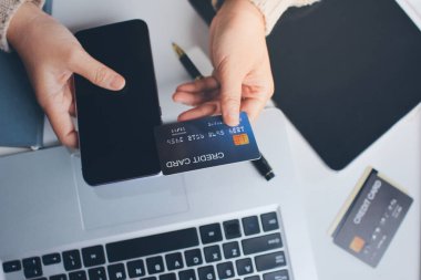 Kapanmış adam dizüstü bilgisayarı kullan kredi kartı kullan cep telefonu kullan kahve dükkanında masaya otur, dinlenme dinlenme dinlenme dinlenme dinlenme boş zamanlarında serbest mobil konsepte odaklan nesneye odaklan