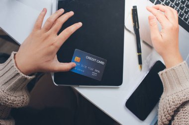 Kapanmış adam dizüstü bilgisayarı kullan kredi kartı kullan cep telefonu kullan kahve dükkanında masaya otur, dinlenme dinlenme dinlenme dinlenme dinlenme boş zamanlarında serbest mobil konsepte odaklan nesneye odaklan